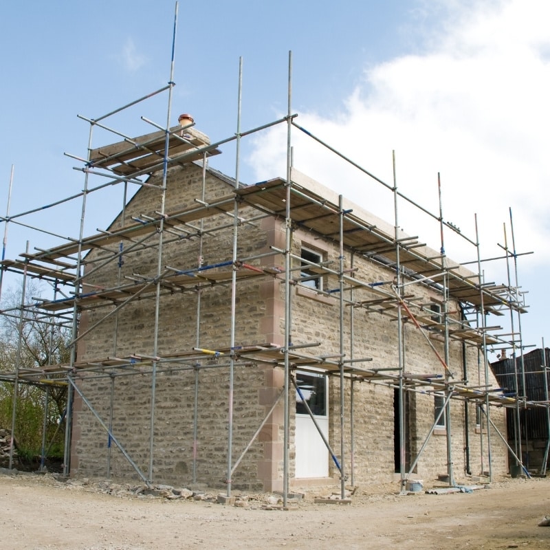 A barn conversion under construction, featuring scaffolding around the structure.
