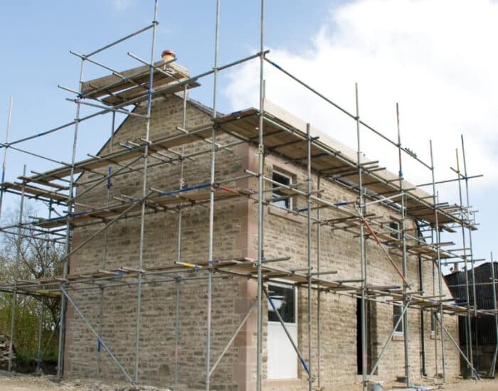 A barn conversion under construction, featuring scaffolding around the structure.
