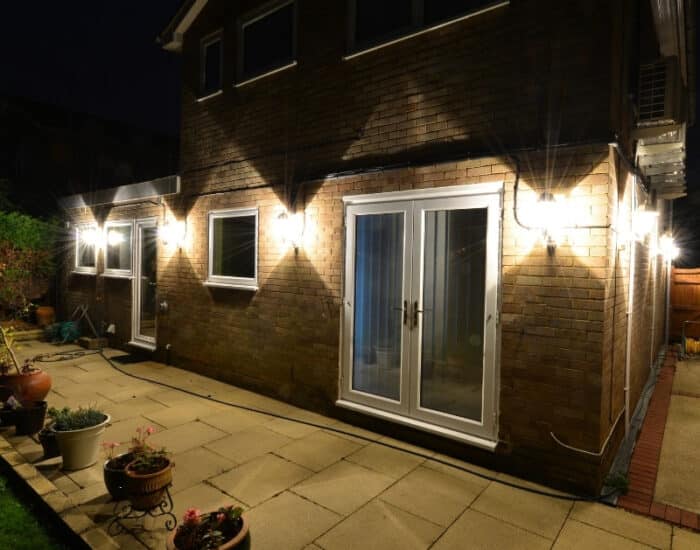 A cozy patio illuminated by outdoor lights, creating a warm ambiance at night.