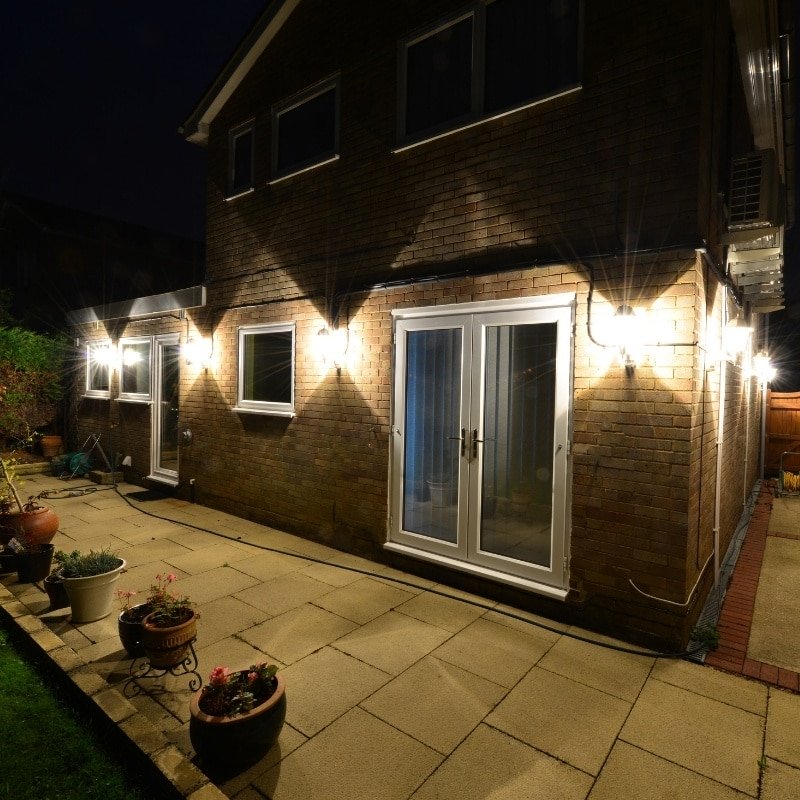 A cozy patio illuminated by outdoor lights, creating a warm ambiance at night.